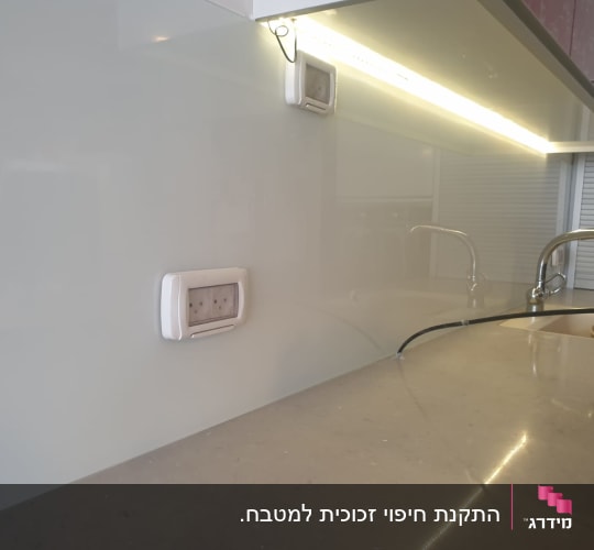 קיר זכוכית במטבח עם ברזים וכיור